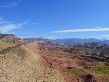 Morocco: View of the Cretaceous rocks outcropping on the low foothills to the Atlas Mountains (in distance), south of Marrakech, Morocco.
