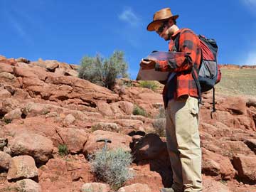 Morocco: PhD Tim Luber (NARG) examines rocks and takes notes in the field.