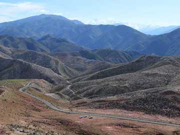 Morocco: Vehicles waiting in valley as we examine outcrop sections, High Atlas, Morocco.