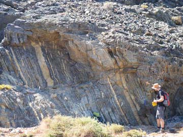 Spain: Tim Luber measuring section of turbidites in the Early Cretaceous deep marine system of Fuerteventura, deep marine systems fieldwork, May 2014, Ajuy, Fuerteventura, Spain.